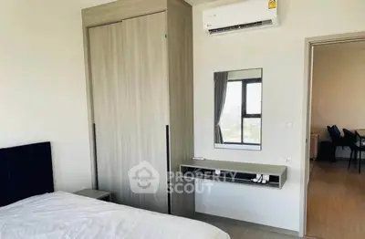 Modern bedroom with built-in wardrobe and air conditioning in a stylish apartment.