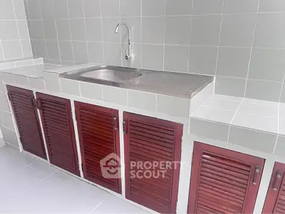 Modern kitchen with sleek stainless steel sink and wooden cabinets