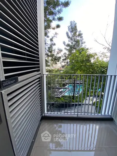 Charming balcony with serene garden view and modern railing design.