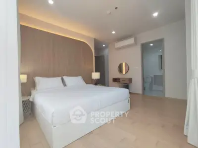 Spacious modern bedroom with elegant lighting and minimalist decor.