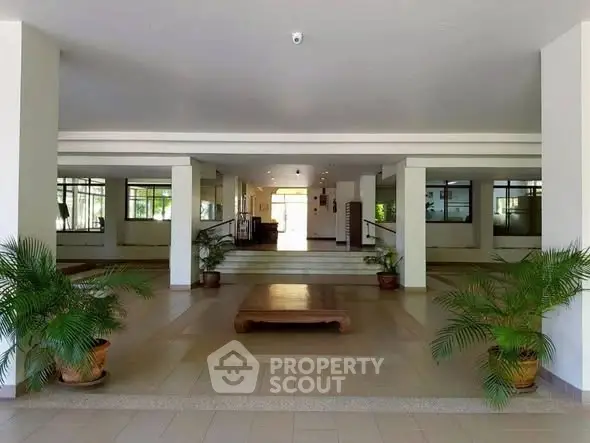 Spacious building entrance with modern design and greenery