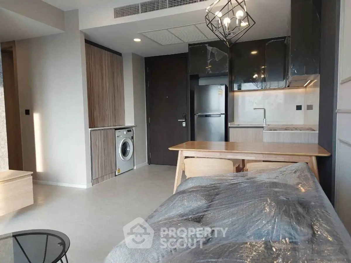 Modern apartment interior with kitchen and living area, featuring sleek appliances and contemporary design.