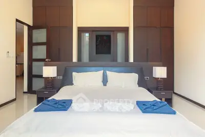 Elegant master bedroom with large bed, crisp white linens, and rich wooden accents offering a luxurious and serene retreat.