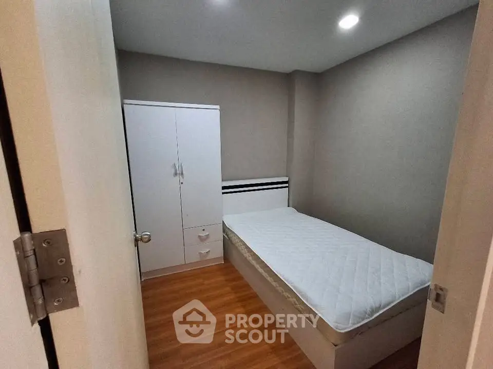 Cozy bedroom with modern design and wooden flooring, featuring a comfortable bed and wardrobe.