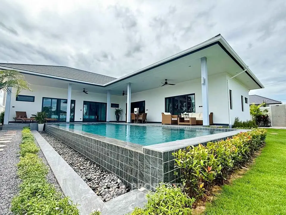 Luxurious modern villa with sleek pool and lush garden, perfect for upscale living.