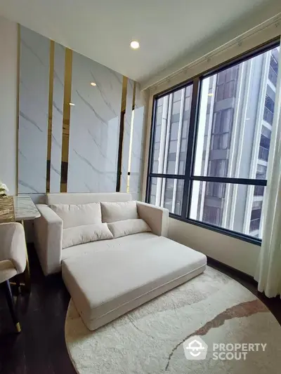 Luxurious corner unit living room with large sectional sofa, marble walls, and expansive windows offering city views, perfect for upscale urban living.