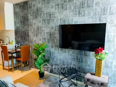 Modern living room with stylish decor, wall-mounted TV, and cozy dining area in a contemporary apartment.