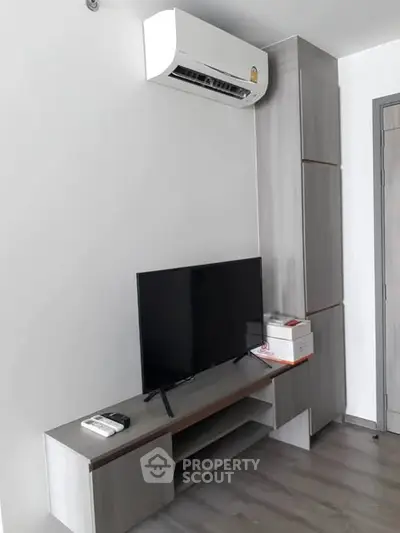 Modern living room with sleek TV stand and air conditioning unit, perfect for comfortable living.