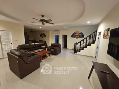 Spacious living room with modern furniture and elegant staircase