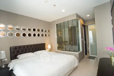 Luxurious modern bedroom with elegant decor and stylish wall mirrors.