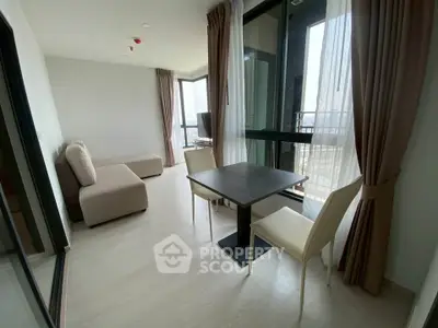Modern living room with large windows and elegant furniture in a high-rise apartment.