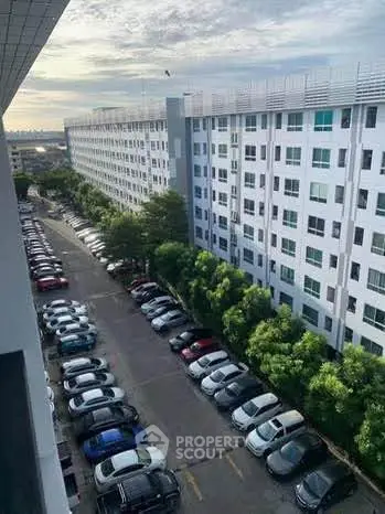 Spacious apartment building with ample parking and lush greenery, ideal for urban living.