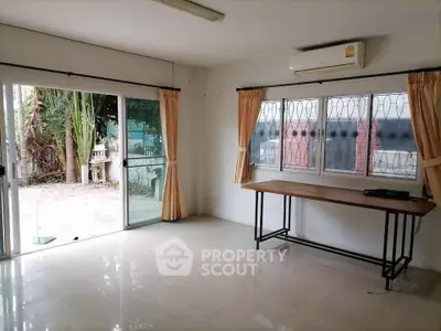 Spacious room with large windows and garden view, perfect for versatile use.