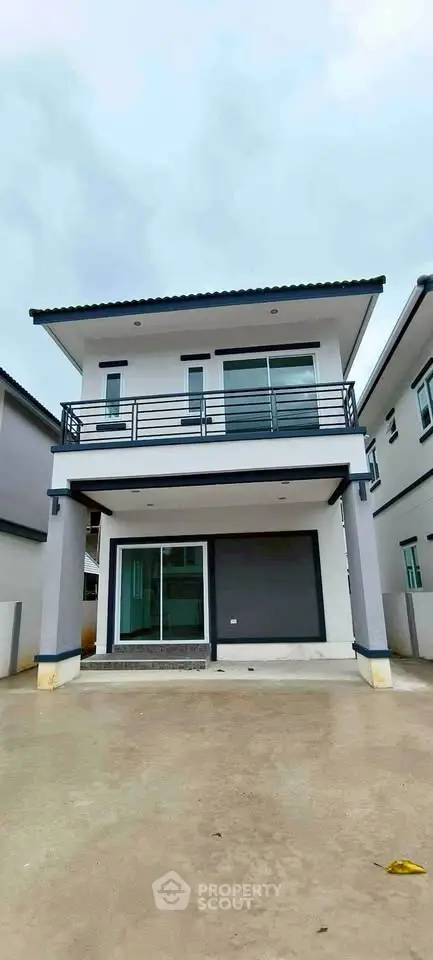 Modern two-story house with sleek balcony and spacious driveway