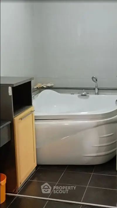Modern bathroom with corner bathtub and sleek design.