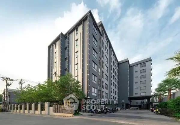 Modern multi-story residential building with sleek design and lush greenery.