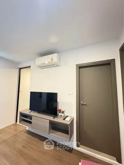 Modern living room with sleek TV setup and air conditioning unit