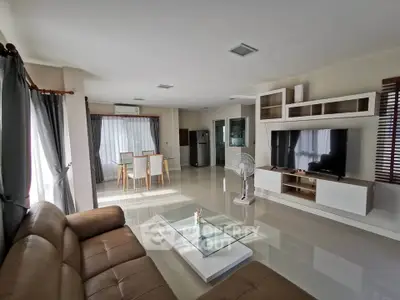 Spacious modern living room with sleek furniture and large windows.