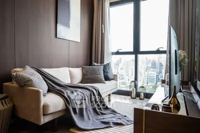 Modern living room with city view, cozy sofa, and stylish decor.