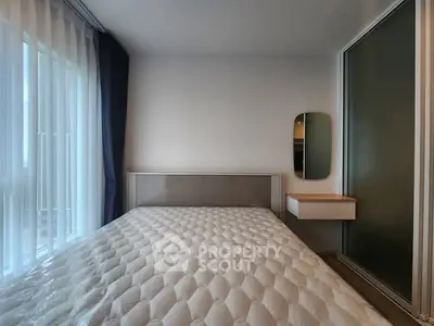 Modern bedroom with minimalist design and large window for natural light.