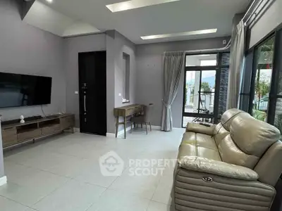 Modern living room with sleek furniture and large windows offering natural light and scenic views.