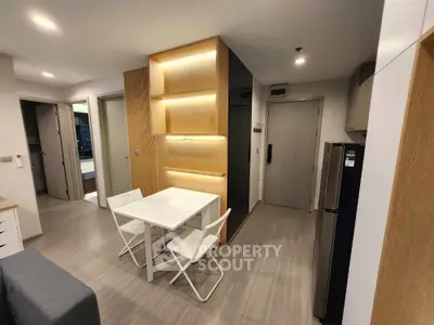 Modern apartment interior with sleek kitchen and dining area, featuring minimalist design and ambient lighting.