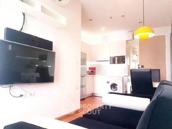 Modern living room with sleek furniture and integrated kitchen appliances.