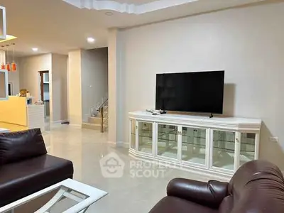 Spacious living room with modern furniture and large TV, perfect for relaxation and entertainment.
