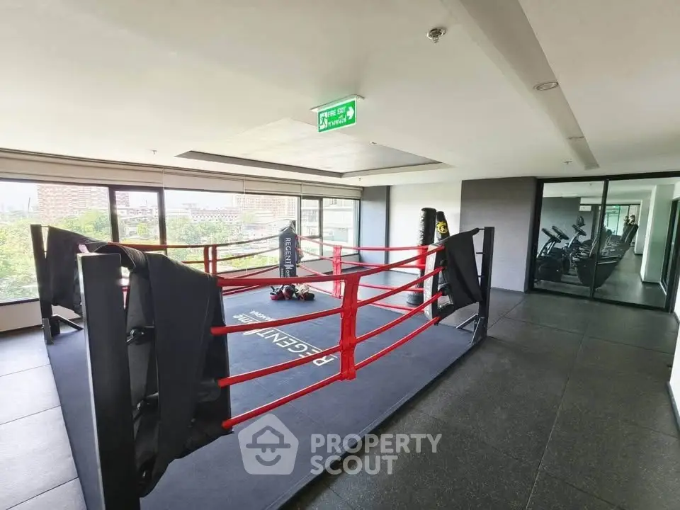 Modern gym with boxing ring and fitness equipment in a high-rise building
