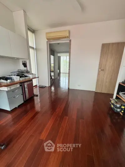 Spacious home office with wooden flooring and ample natural light