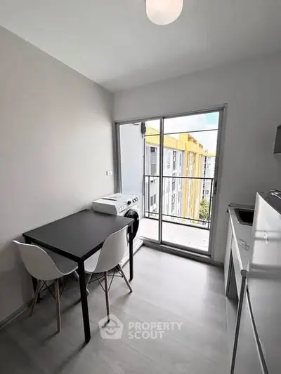 Modern kitchen with dining area and balcony view in a stylish apartment.