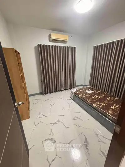 Cozy bedroom with air conditioning and modern tile flooring