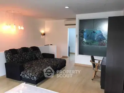 Modern living room with stylish sofa and wall art, featuring sleek wooden flooring and ambient lighting.