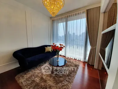 Luxurious living room with elegant chandelier and city view, featuring plush sofa and stylish decor.