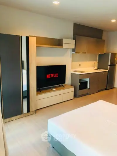 Modern studio apartment with sleek kitchen and cozy living area, perfect for urban living.