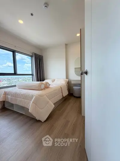Cozy bedroom with a stunning city view, featuring modern decor and ample natural light.