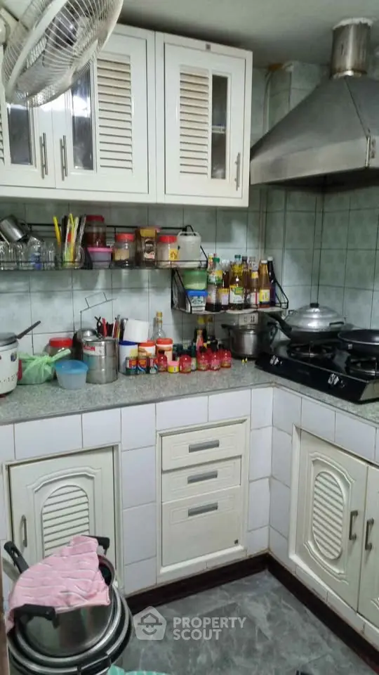 Cozy kitchen with closed layout and gas stove, featuring ample storage and modern appliances.