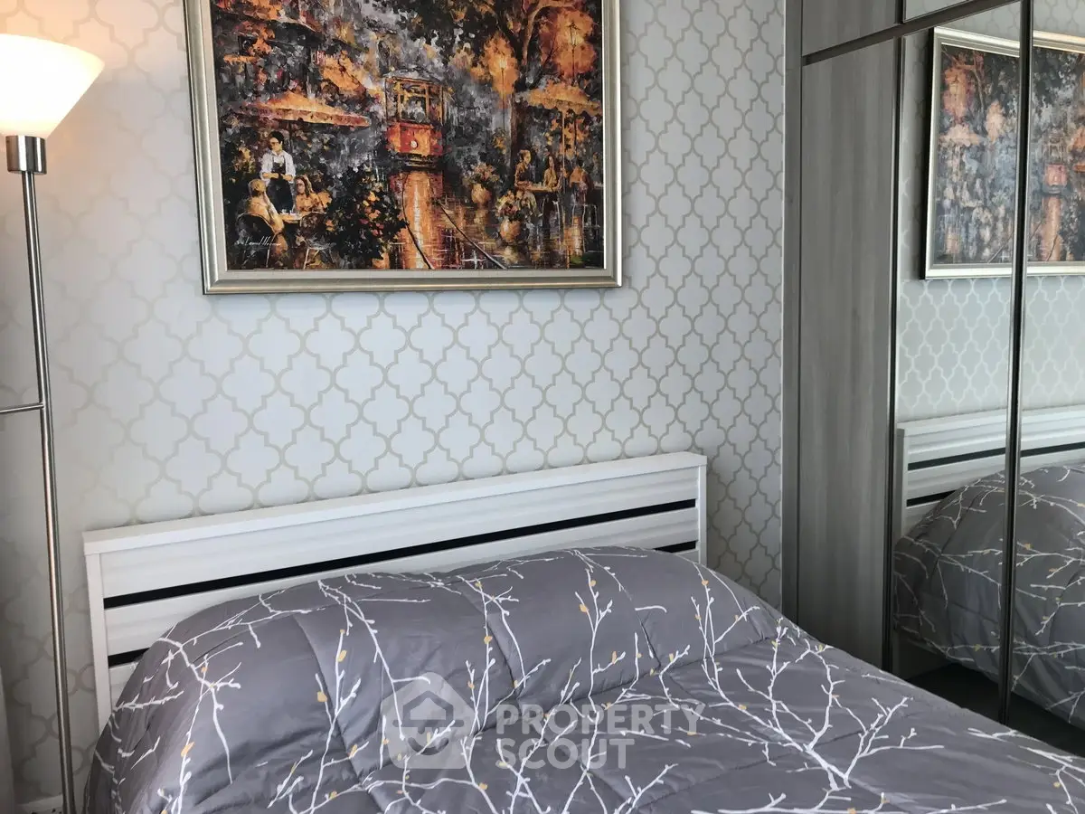 Chic bedroom with stylish decor and mirrored wardrobe in modern apartment.