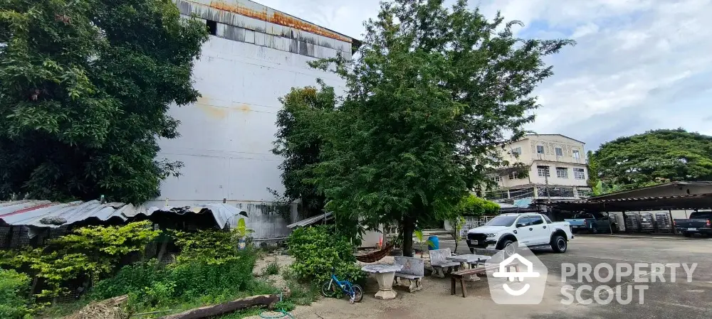 Spacious outdoor area with trees and parking space in urban setting