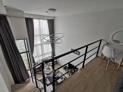 Modern loft apartment with high ceilings and stylish decor, featuring a mezzanine and large windows.