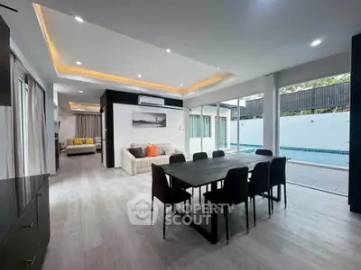 Spacious modern living and dining area with pool view and elegant decor.