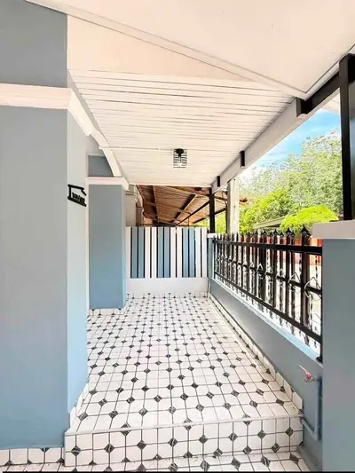 Charming outdoor patio with stylish tile flooring and elegant railing, perfect for relaxation and entertaining.