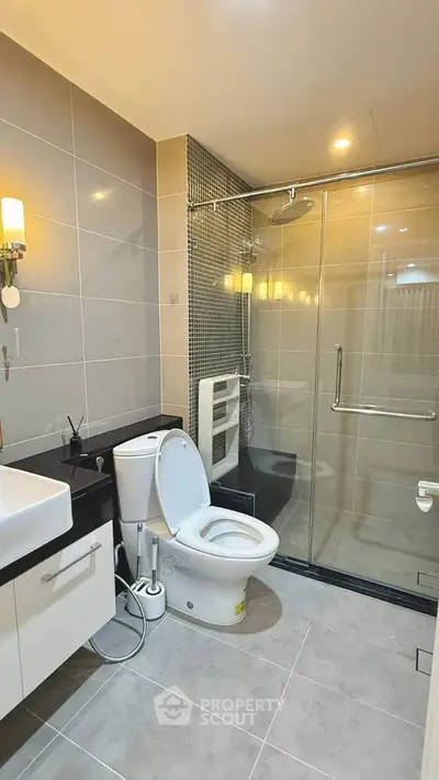 Modern bathroom with glass shower and sleek fixtures in a contemporary apartment.