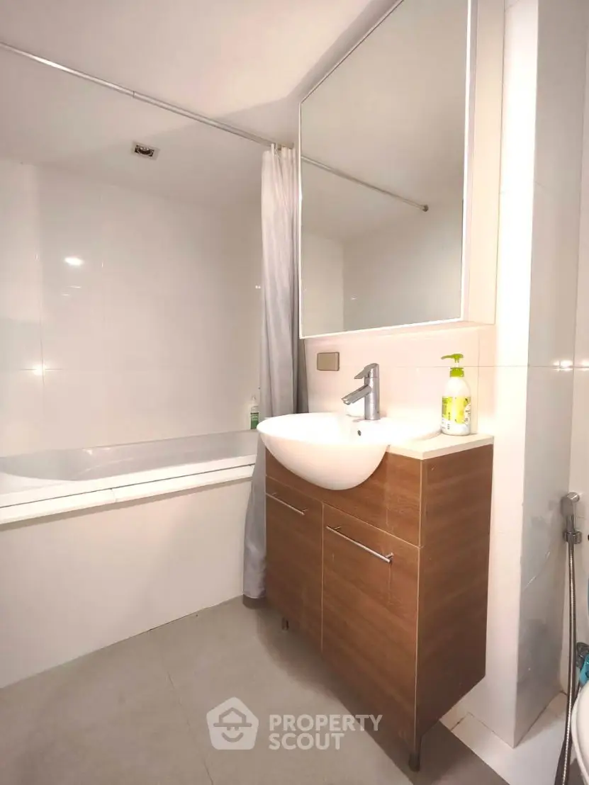 Modern bathroom with sleek vanity and bathtub in contemporary apartment.
