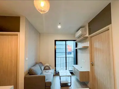 Modern living room with sleek furniture and large window for natural light.
