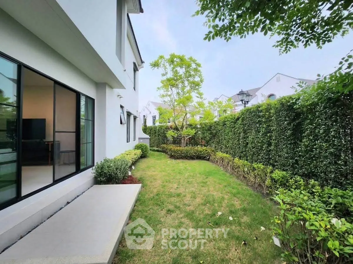 Charming garden view of modern home with lush greenery and spacious outdoor area.