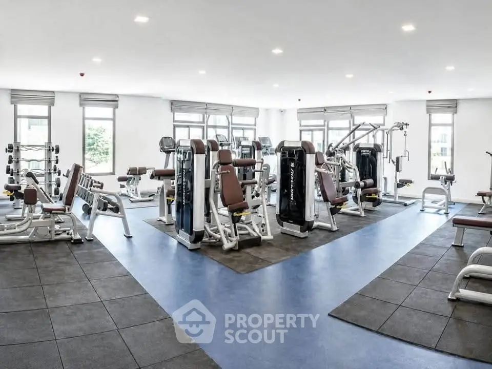 Spacious modern gym with state-of-the-art equipment and ample natural light.
