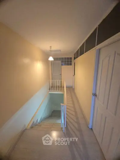 Spacious hallway with staircase and modern lighting in a residential property