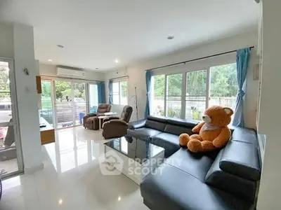 Spacious living room with large windows and cozy seating area