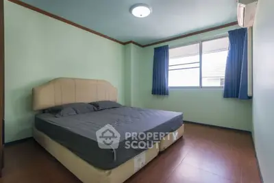 Spacious bedroom with modern decor and natural light from large window.